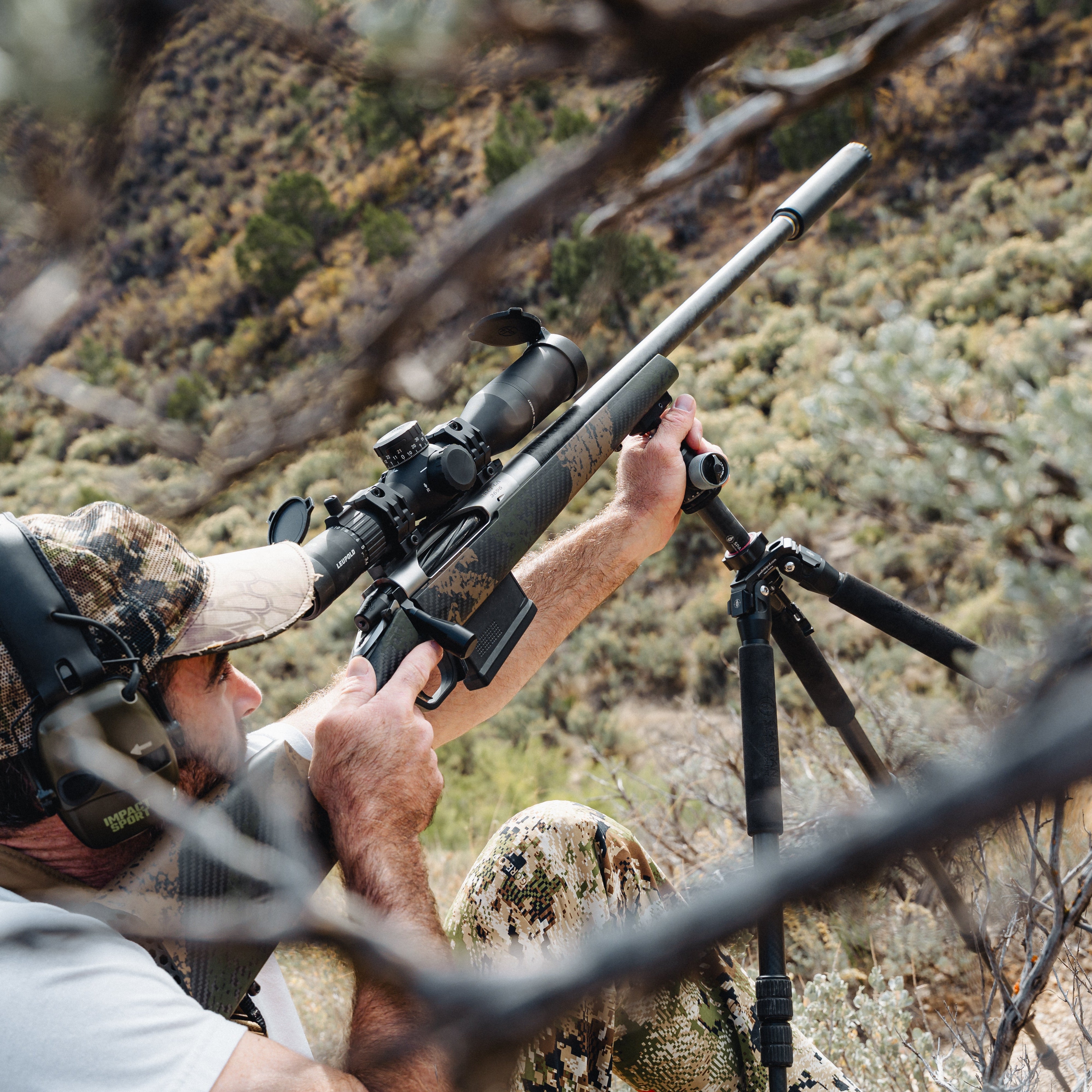 Hunter with rifle and scope in a natural outdoor setting