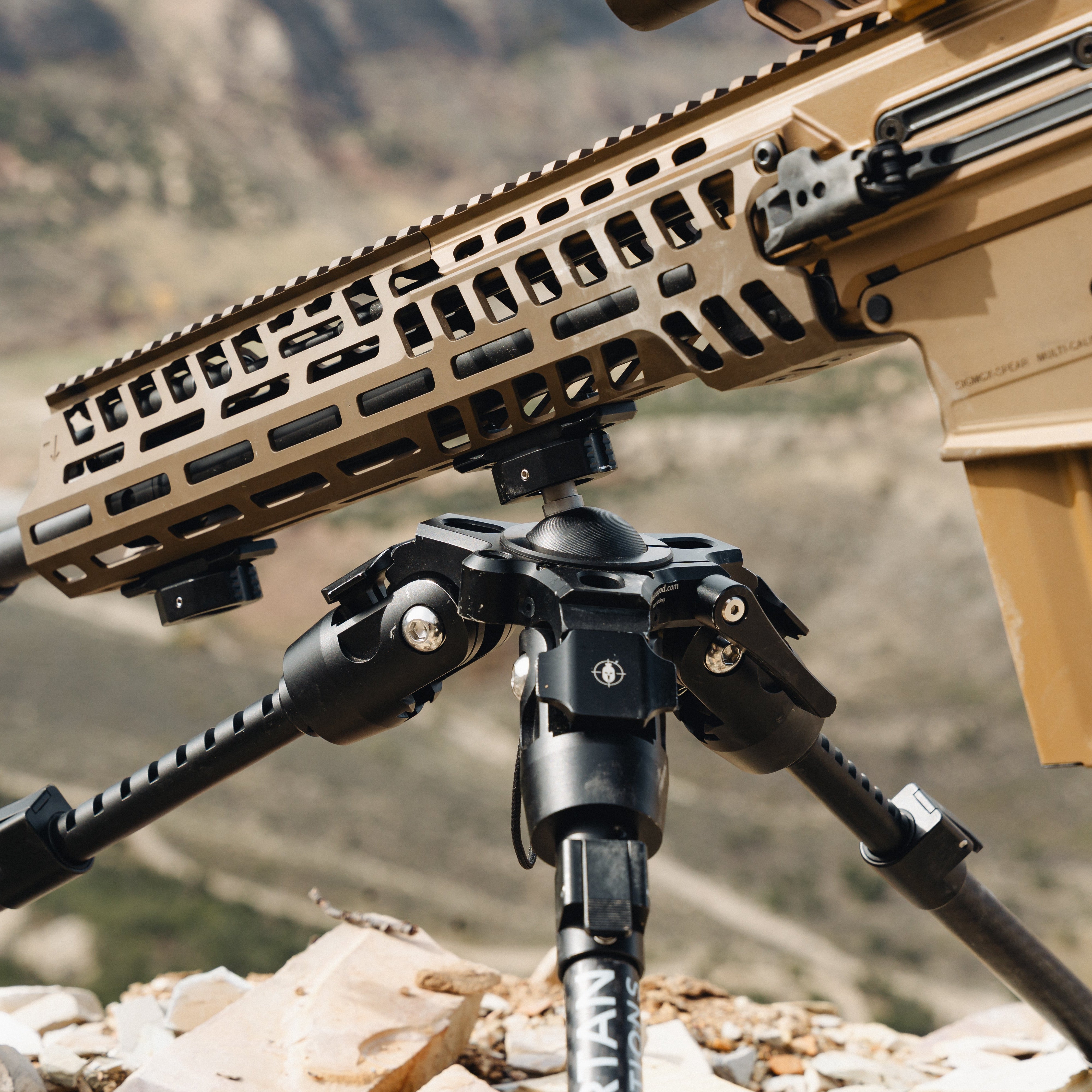 Rifle on a bipod with a mountainous landscape in the background